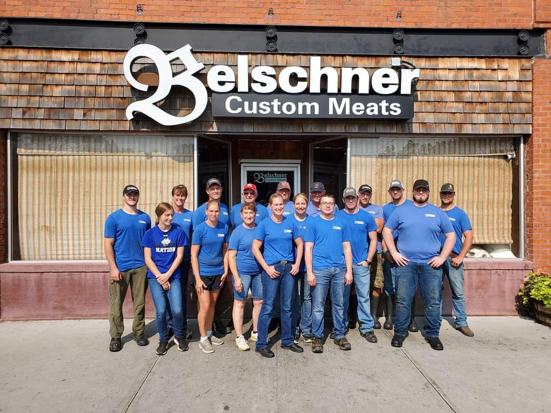A picture of Belschner's Custom Meat Staff in front of their building.