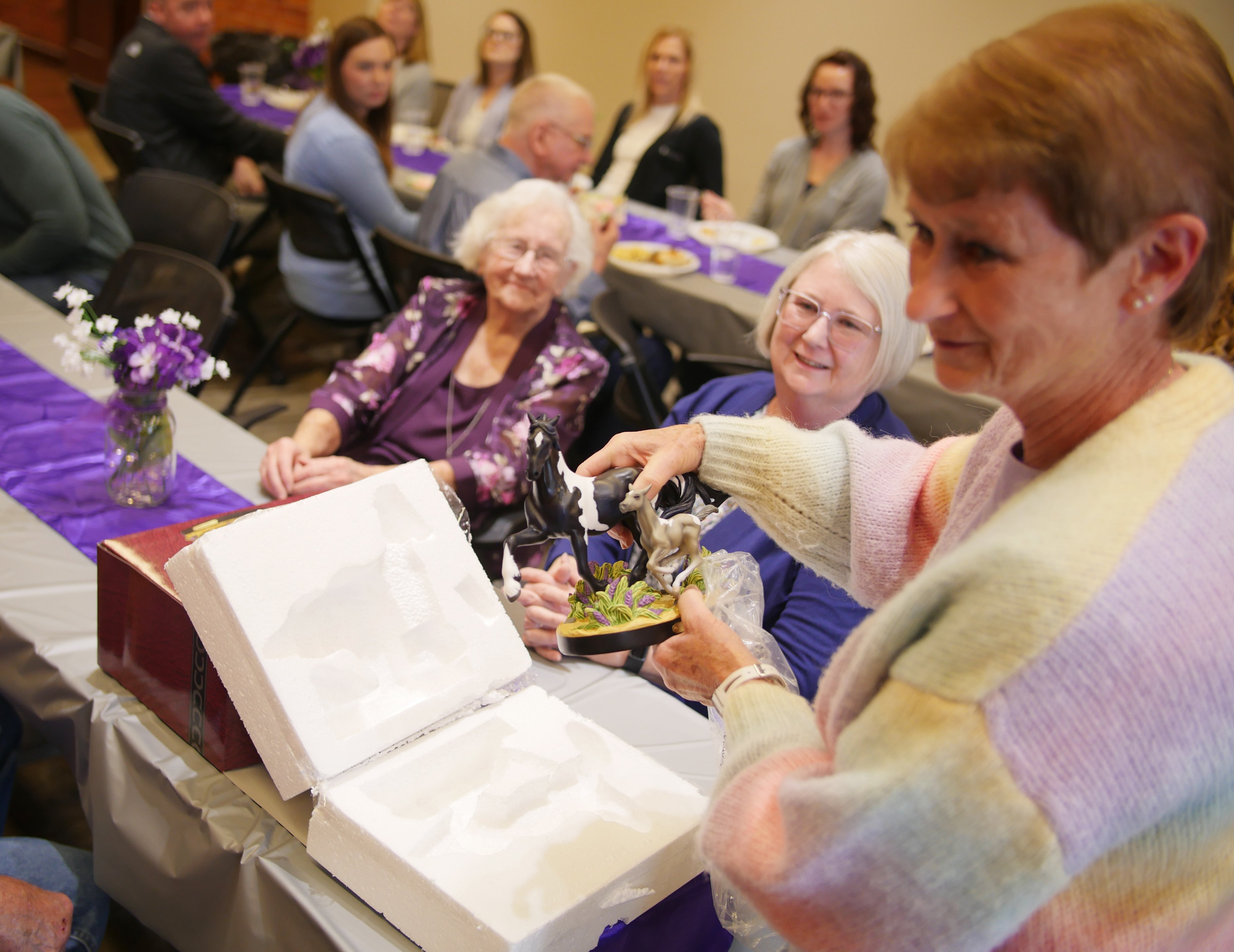Lila opens one of her gifts at her anniversary celebration.