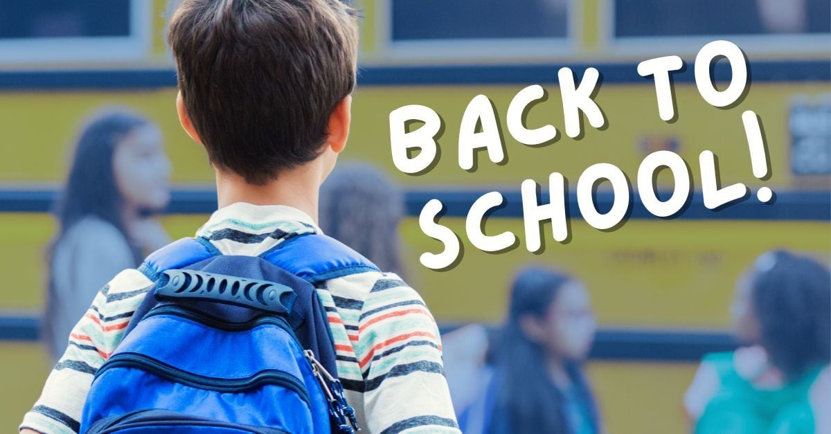 young child standing by school bus