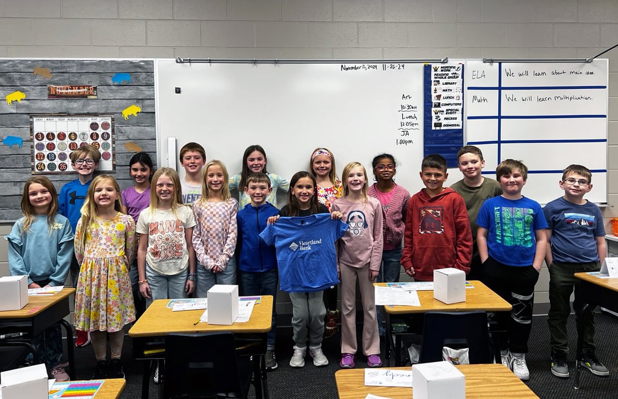 Heartland Bank Marketing Director teaching financial literacy to elementary students during a Junior Achievement volunteer session.