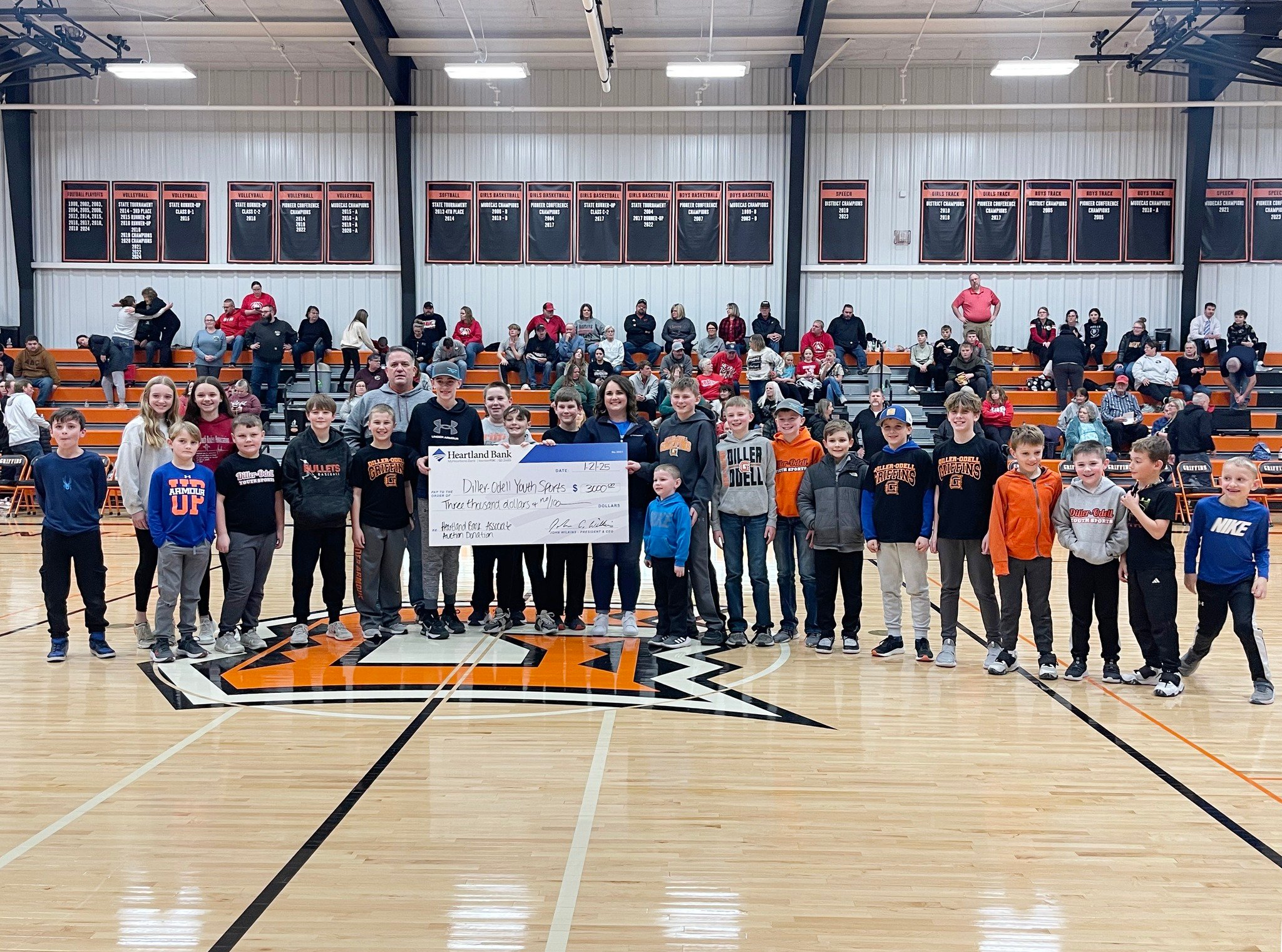 Heartland Bank presenting a donation to the Diller/Odell Youth Sports Program during a sponsored Heartland Bank Night at the Diller/Odell home basketball game.