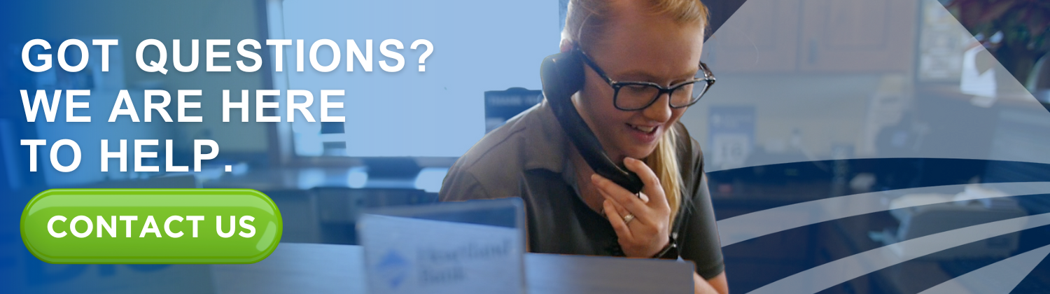 Heartland Bank associate smiles while speaking on the phone at the front desk. A banner beside her reads “Got questions? We are here to help,” with a bright green “Contact Us” button.
